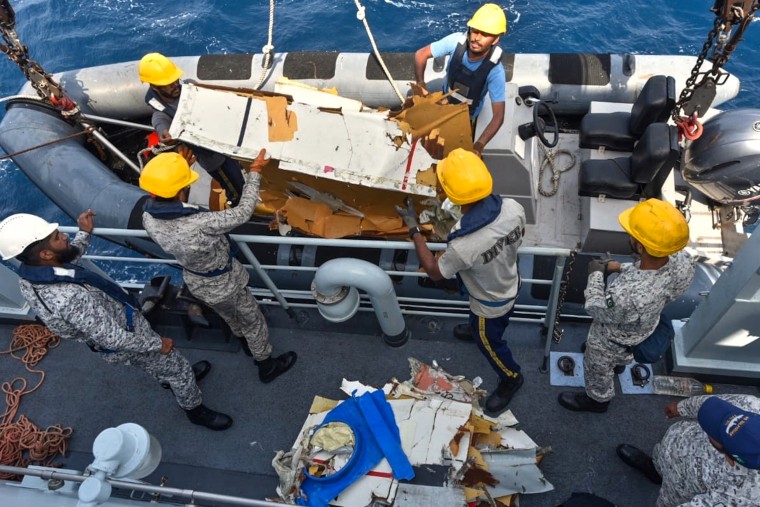 Pakistan Navy personnel shift the wreckage of a cargo plane.