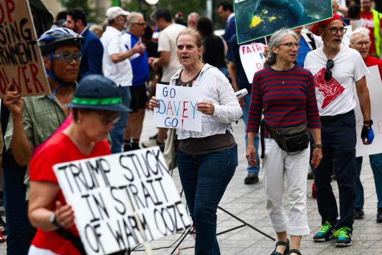 Los manifestantes marchan antes de la lectura de cargos del ex atleta olímpico David Hearn el 9 de julio de 2026 en Washington, DC. Hearn fue acusado de destrucción de propiedad después de supuestamente dañar la piscina reflectante del Lincoln Memorial.