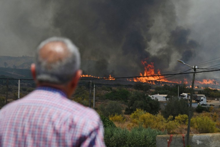 A man watches a wildfire burning close to houses near Bedar, Spain, on July 10, 2026. 