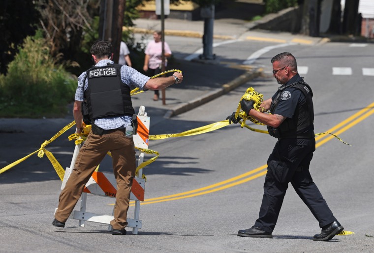 Authorities remove police tape from the scene of an ICE shooting on July 13, 2026.