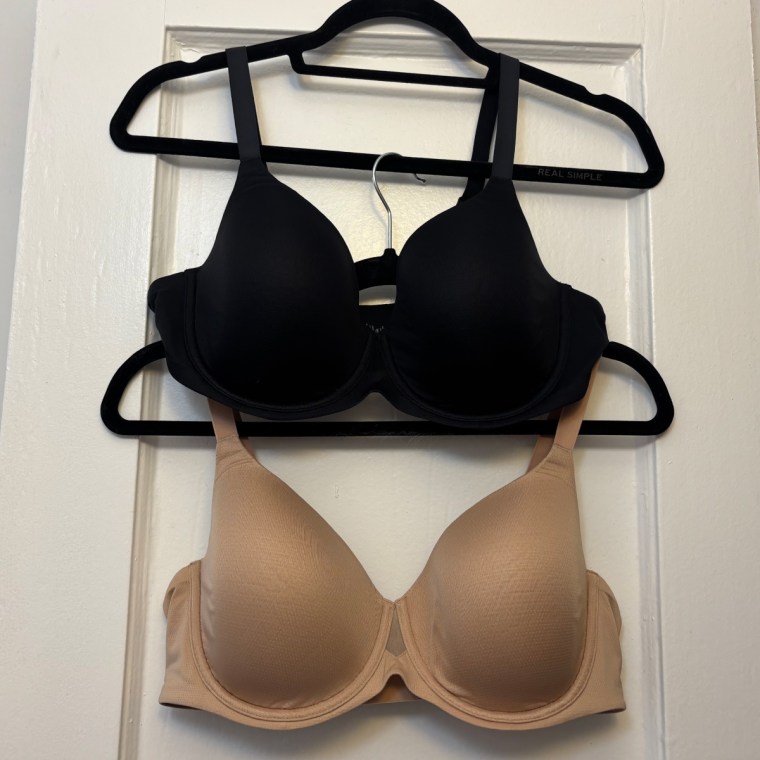 Two Thirdlove TempSync T-Shirt Bras on black hangers, one on top of the other: top (black) and bottom (nude)
