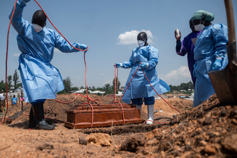 Teams from the International Federation of the Red Cross and Red Crescent Societies prepare for burial at Mbiyo cemetery.