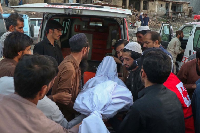People place the body of a miner recovered after an explosion inside a coal mine