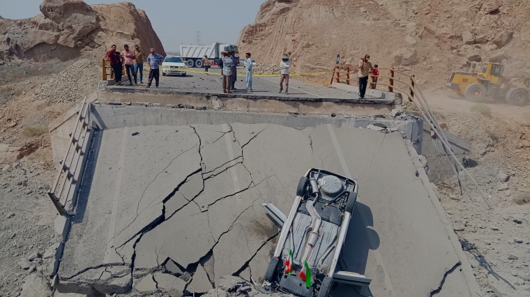 Un auto volcado yace sobre un tramo de un puente destruido tras un ataque en la provincia de Hormozgan, en el sur de Irán, el 18 de julio de 2026.