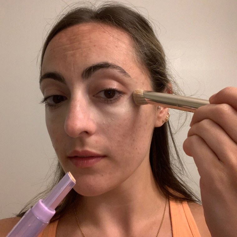 Murphy applying the Tarte Shape Tape Blur Concealer Stick.