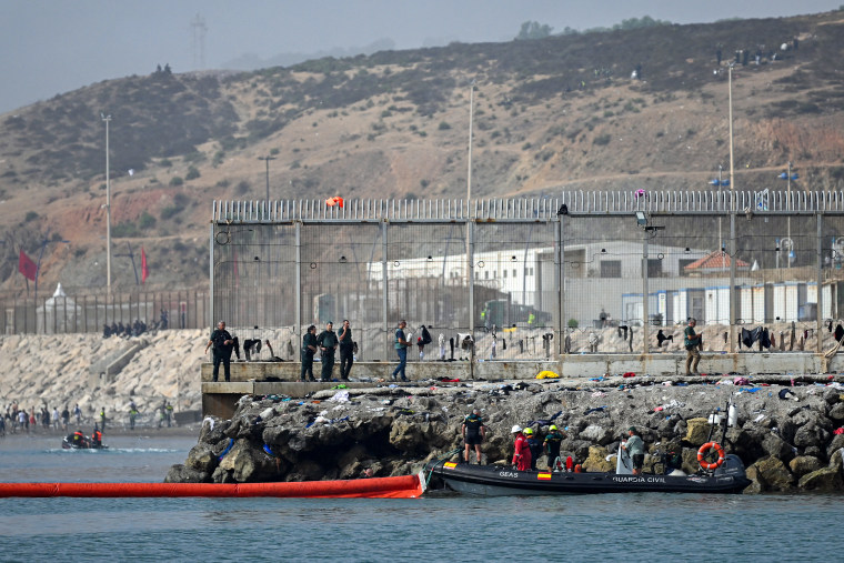 A 500-meter-long (1,640 feet) pneumatic barrier is deployed in the water by a Spanish Guardia Civil boat.