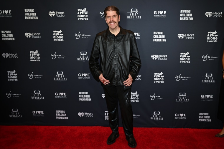 Perez Hilton posing for a portrait to be taken.