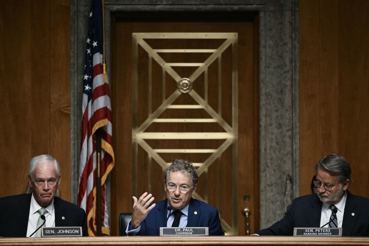 Sen. Rand Paul is flanked Thursday by Sens. Ron Johnson, left, and Gary Peters.Brendan Smialowski / AFP via Getty Images