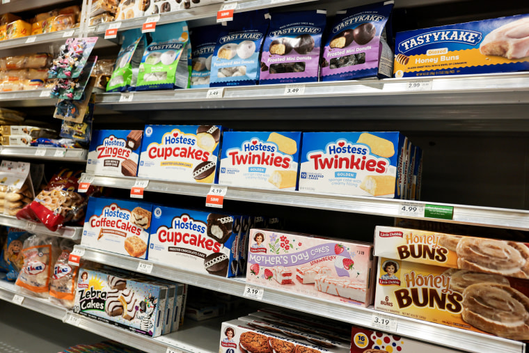 Desserts on rows of grocery store shelfs. Hostess, TastyKake, and Little Debbie packaged sweets can be seen