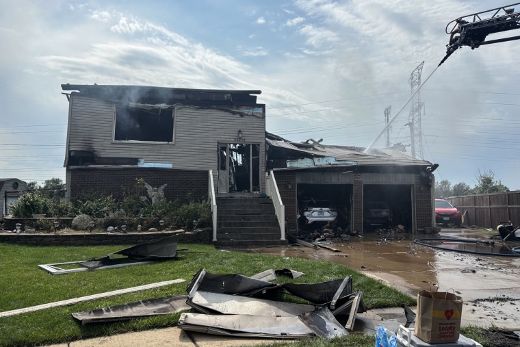 A house burned down after a storm hit. Fire truck waters down the house.
