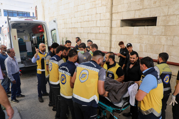 Members of the White Helmets carry the body of Mohammad Ghamira.
