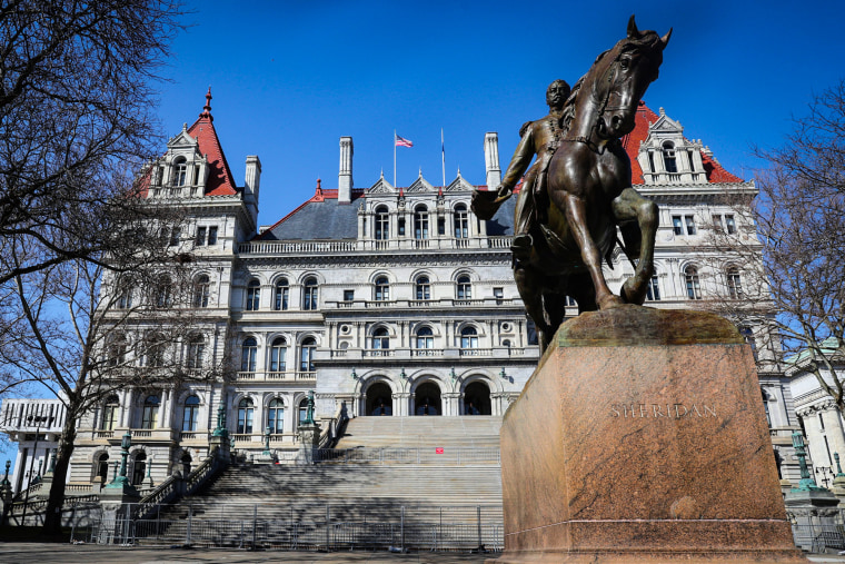 The Albany New York State Capital Building exterior, with a statue of a man riding a horse on a pedestal in front, the name Sheridan is engraved on the front of the pedestal