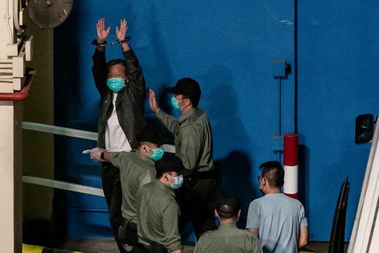 Pro-democracy activist and former lawmaker Lee Cheuk-yan makes a gesture with his cuffed hands.