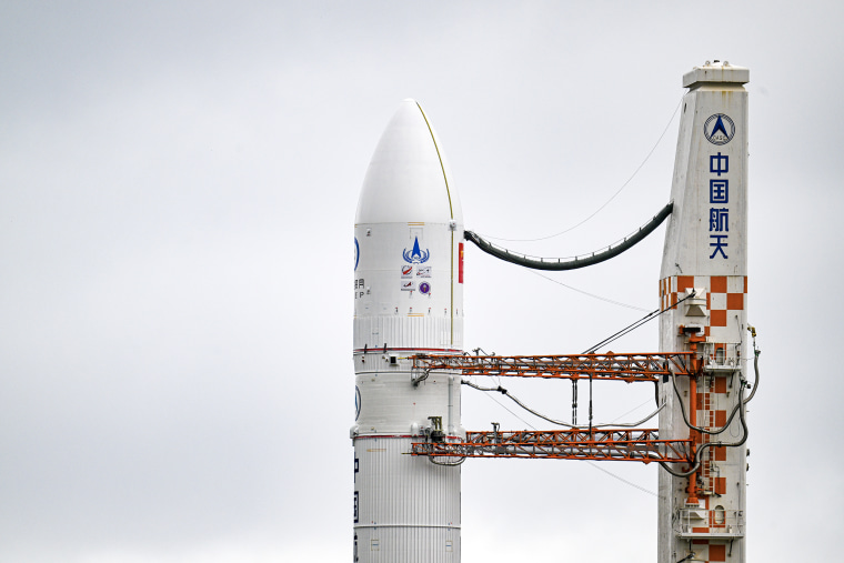 A rocket and booster rise against a gray sky.