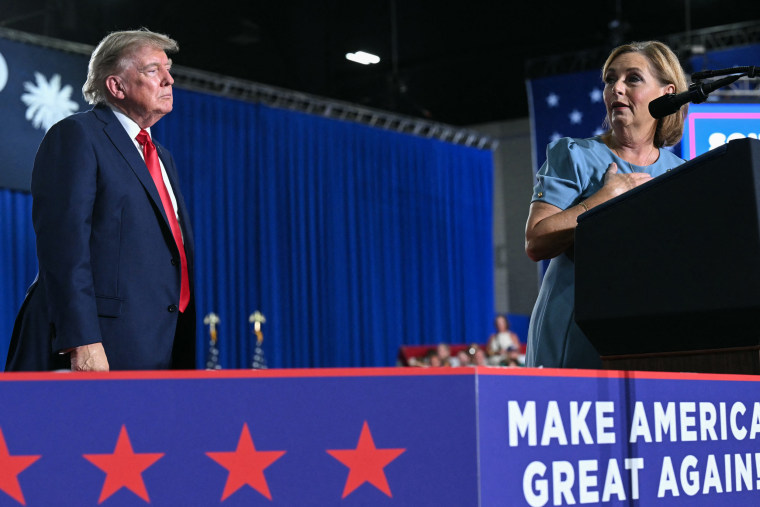 U.S. President Donald Trump listens to US Senator Darline Graham.