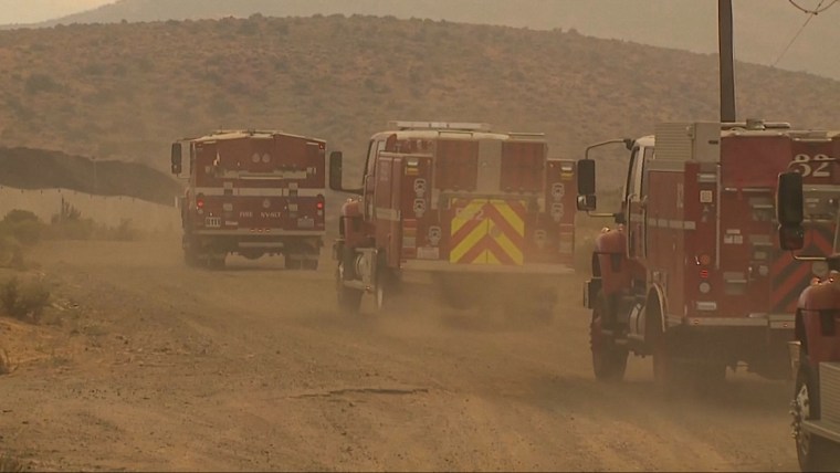 Ambulances and fire trucks drive through a smoky landscape