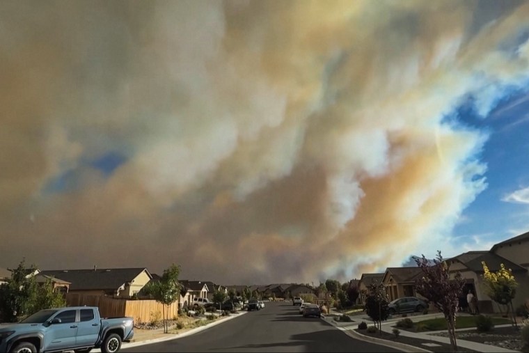 Smoke clouds billow over a residential neighborhood