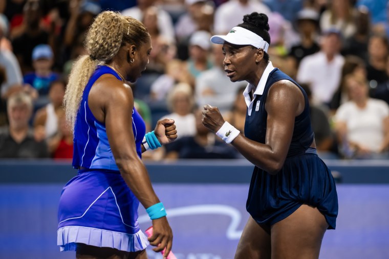 Serena Williams and Venus Williams reacting during a tennis game.