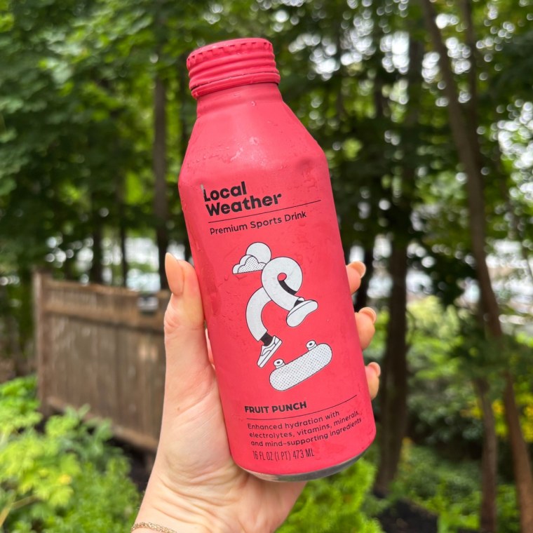 A woman holding a bottle of Local Weather’s Fruit Punch Premium Sports Drink.