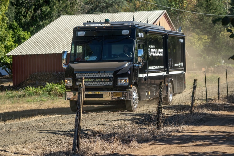 A law enforcement mobile command center driving down a dirt road.