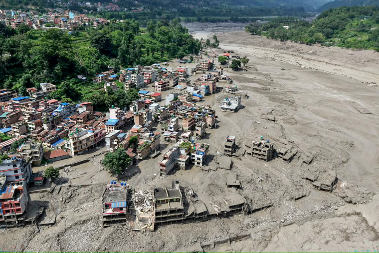 Houses lie partially submerged in muddy water