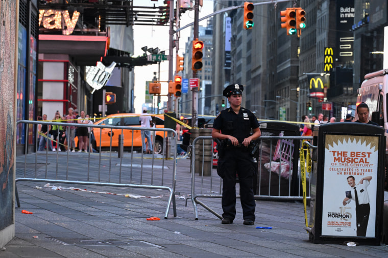 NYPD officers stands near a barricaded sidewalk in Times Square.
