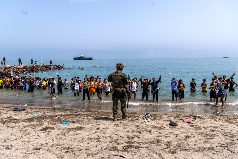 Spanish soldiers block access to the beach for migrants who crossed from Morocco to Ceuta on July 31.