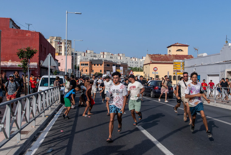 Migrants fleeing Spanish police on July 31 after crossing from Morocco to Ceuta.