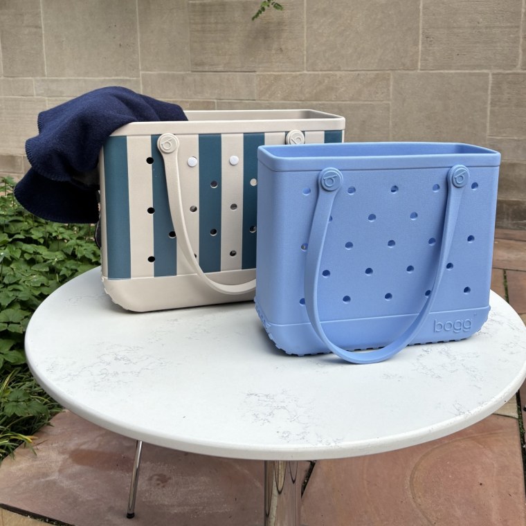A large blue and white striped Bogg Bag sitting next to a small light blue Bogg Bag.