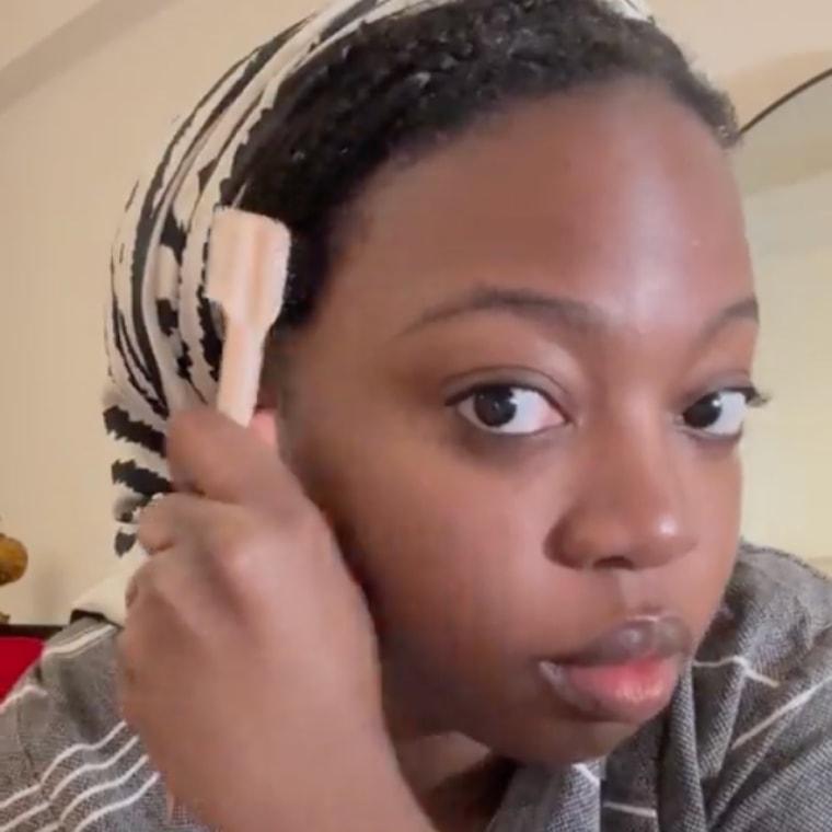 Woman applying edge-styling tool to edges of hair