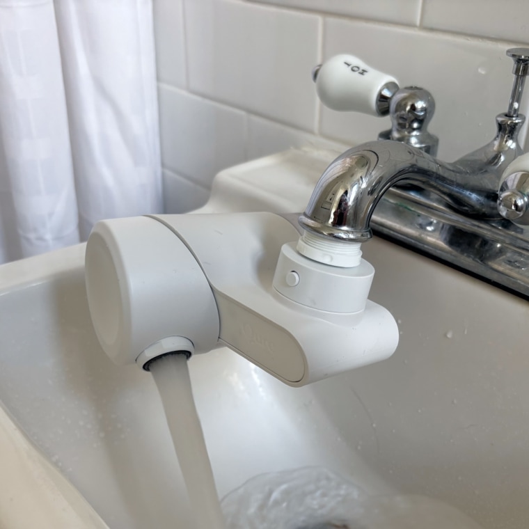 A white Qure Faucet Filter installed on a bathroom sink.