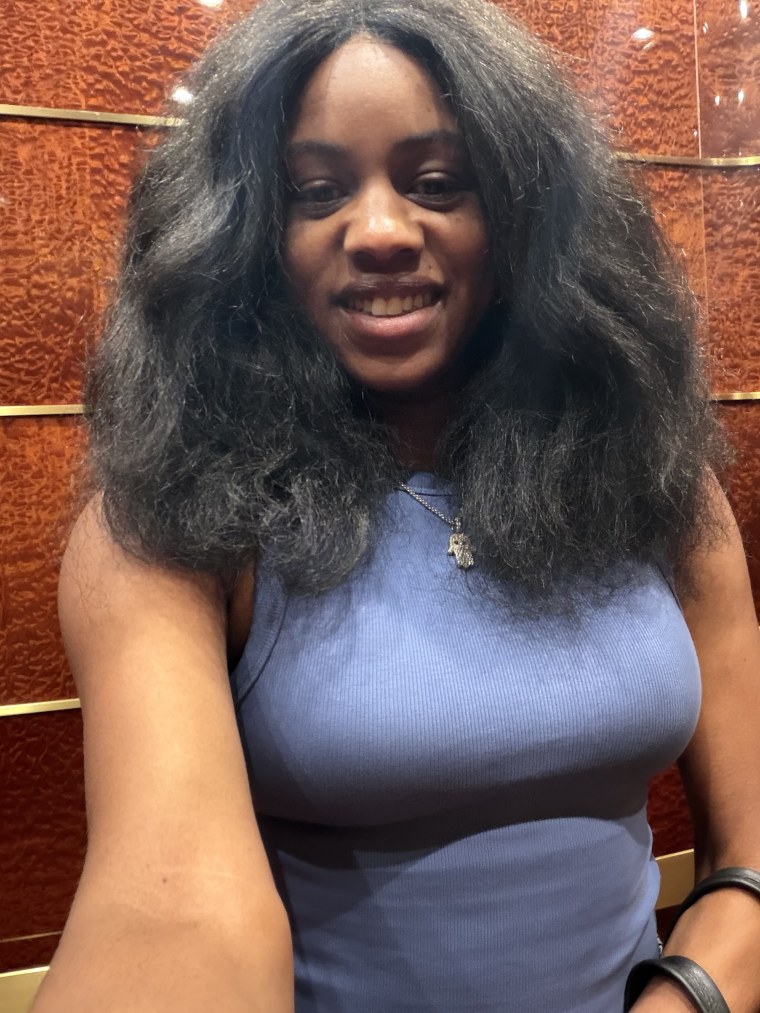 A woman posing in a blue tank top