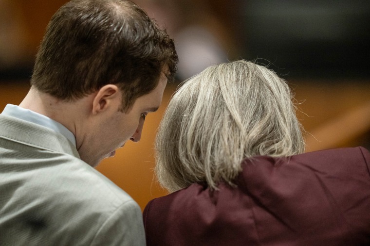 Tyler Robinson, left, speaking to his attorney.