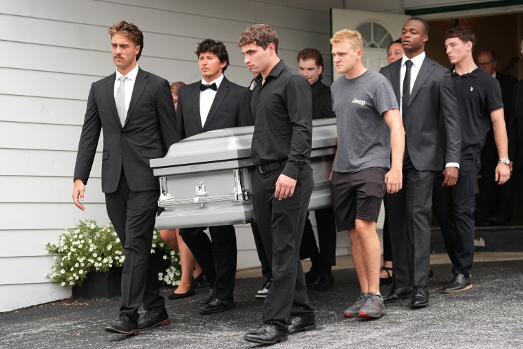 Pallbearers carry a casket 