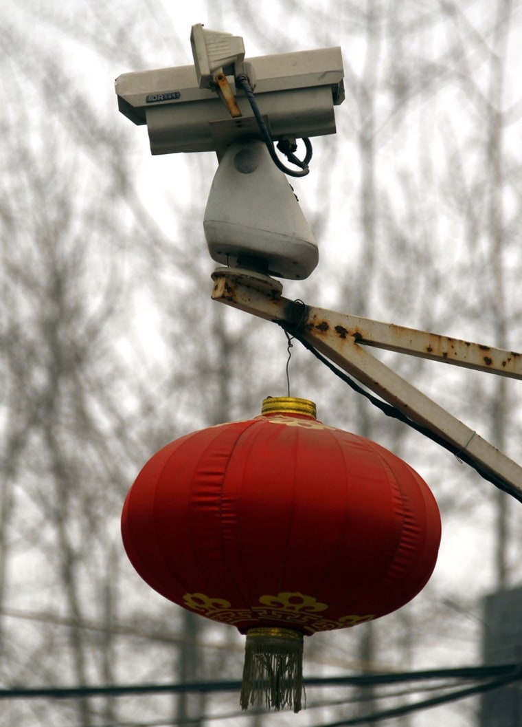 A Chinese lantern hangs underneath a security camera afixed to a light pole that looks into the studio of dissident Chinese artist Ai Weiwei in Beijing on January 17, 2012.