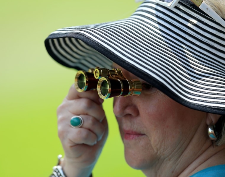 A spectator wears a floppy hat, part of a team give away for those