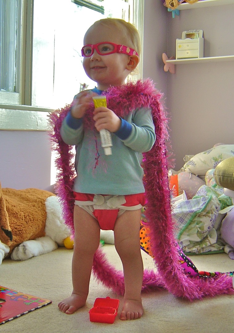 Elisabeth, 1, knows a real super hero can carry off wearing a fether boa.