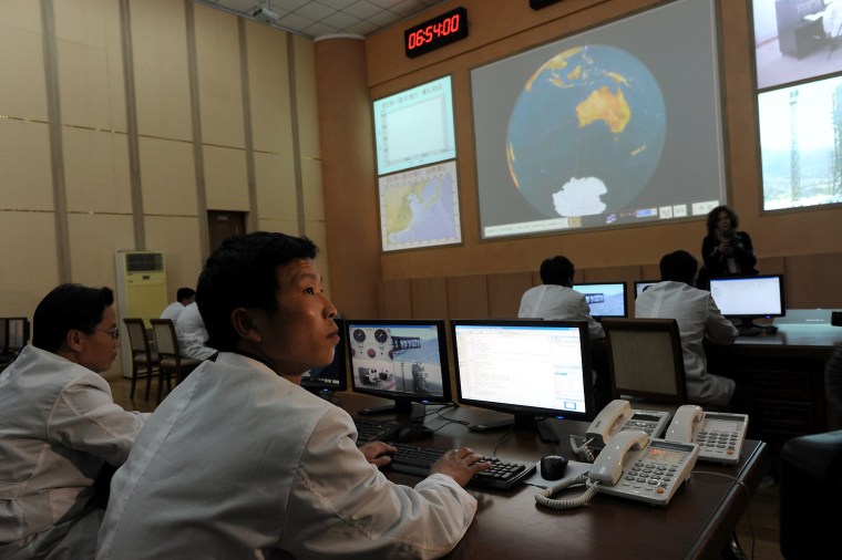 North Korean technicians work in the control room of the Tongchang-ri space center on April 8.