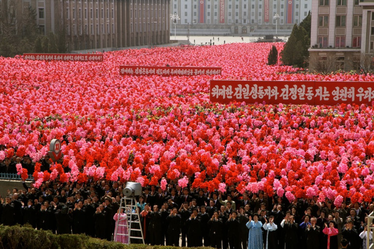 From atop Jangdaezae hill in Pyongyang on Monday, the visual effect of thousands of people waving flower wreaths was stunning during the event to commemorate the unveiling of a new mural of Kim Jung-il, who died last year.