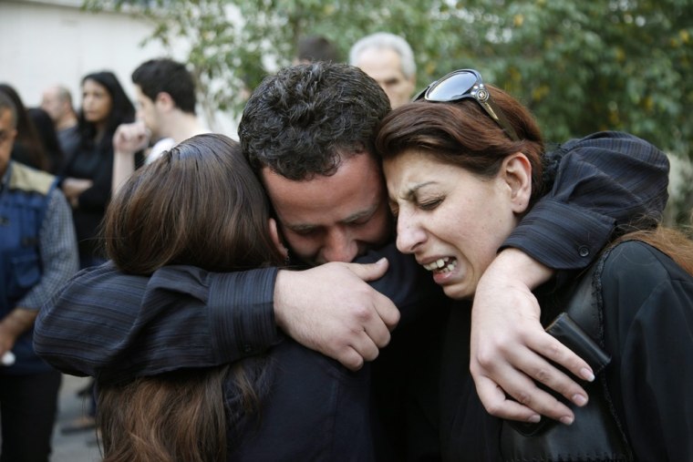 Unidentified mourners grieve as the coffin of cameraman Ali Shaaban passes in front of the Al-Jadeed TV building ahead of his funeral in Beirut, Lebanon, on April 10, 2012. Shabaan was killed on Monday and two others were wounded when they came under fire from Syrian army soldiers while they were filming along the Lebanese-Syrian border.