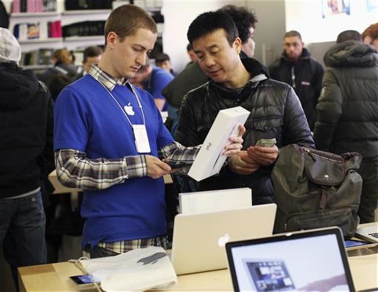 An Apple Store employee sells Apple's new iPad to a customer at the 5th Avenue Apple Store in New York.