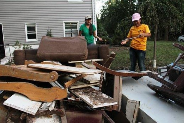The Sedano sisters pick through the belongs outside their flooded Cranford home in August 2011.