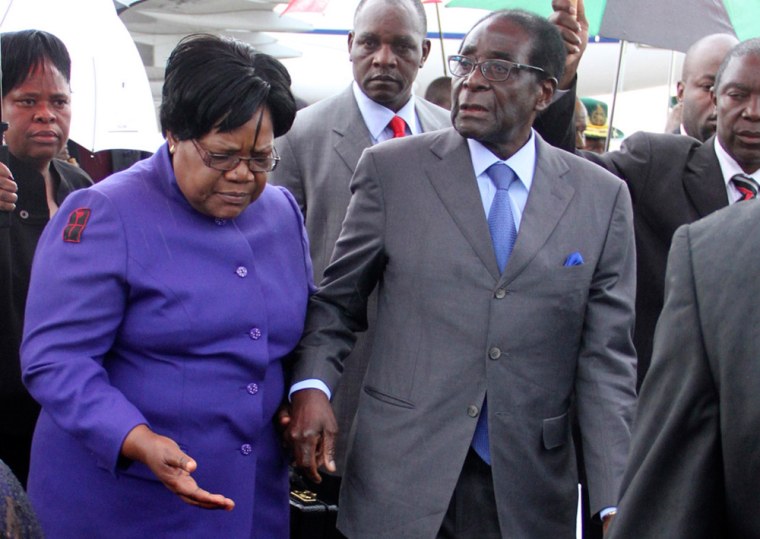 Zimbabwean President Robert Mugabe is greeted by Vice President Joice Mujuru as he returns home to Harare, April 12, 2012, after a trip to Singapore that had ignited speculation the veteran leader was seriously ill.