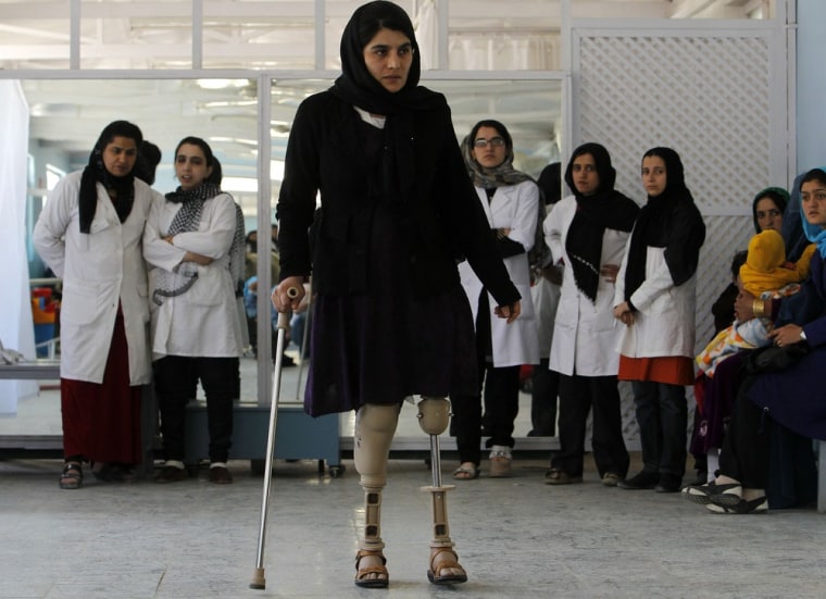 A disabled Afghan woman exercises with her prosthetic legs at the Orthopedic Center of the International Committee of the Red Cross in Kabul on April 11.