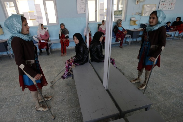 A disabled Afghan girl exercises with her prosthetic legs at the Orthopedic Center of the International Committee of the Red Cross in Kabul.