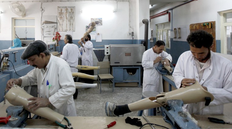 Afghan employees work on prosthetic legs at the Orthopedic Center of the International Committee of the Red Cross in Kabul on April 11.