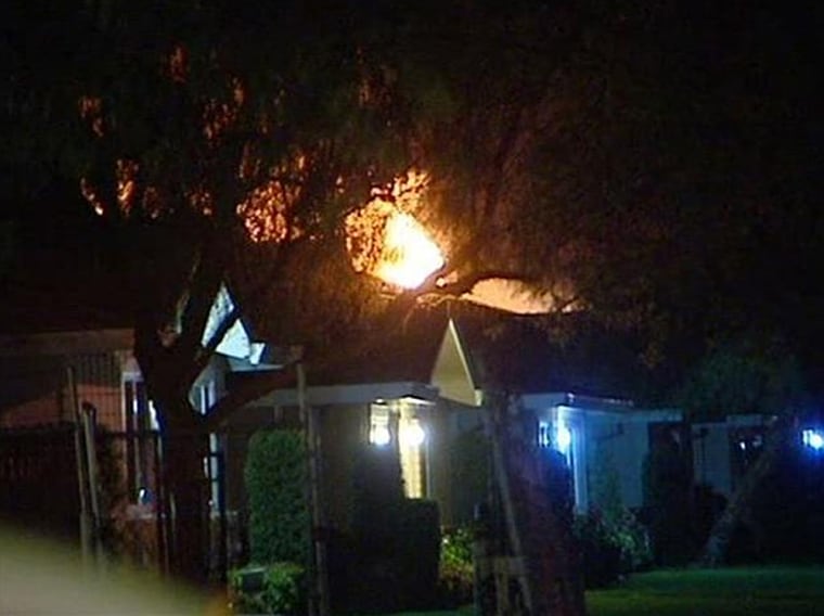 Large flames shot out of an apartment building in Modesto, Calif. late Thursday night where a suspect is believed holed up after a sheriff's deputy and civilian were shot to death.