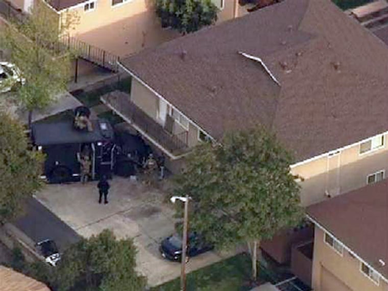 FBI and SWAT teams surround an apartment building in Modesto, Calif. Thursday.