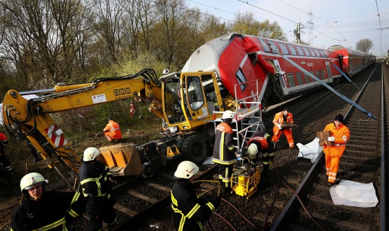 Emergency services and employees of German rail operator Deutsche Bahn attend the scene following a crash between a regional train and a digger in Muehlheim near Offenbach, 9 miles south of Frankfurt, on April 13, 2012.