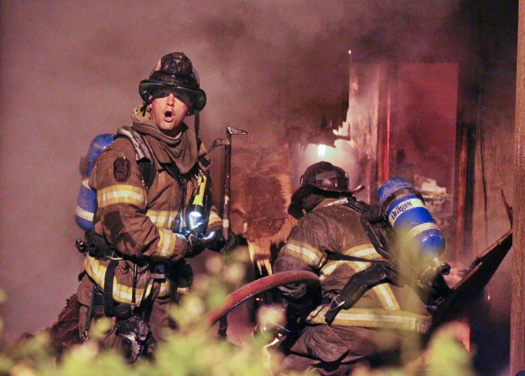 Firemen work at the scene of a condominium complex fire early on April 13, in south DeKalb County in Georgia.